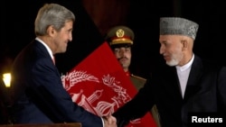 Afghan President Hamid Karzai (left) and U.S. Secretary of State John Kerry (right) announced that they had reached a partial deal earlier this month.