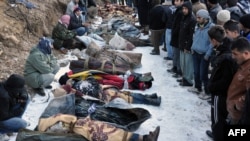 Locals gather in front of the bodies of people who were killed in an air strike in southeastern Turkey on December 29.