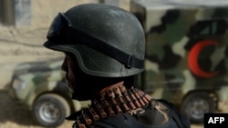 An Afghan security troop stands guard as an ambulance arrive near the entrance gate of the Presidential Palace in Kabul after the Taliban attack on June 25.