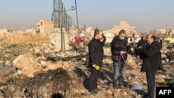 TV journalists stand amid the wreckage of the Ukrainian plane, which was carrying 176 passengers, on January 8.