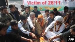 Students in Delhi on November 26 pray for victims of the Mumbai terror attacks one year earlier.