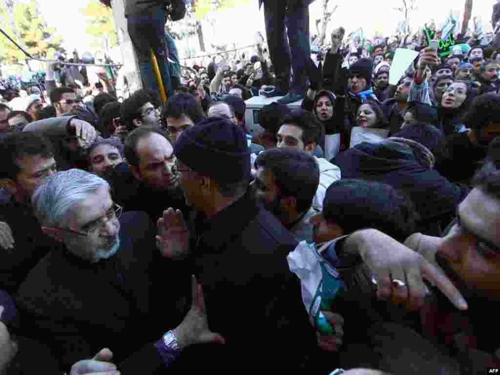 Iranian opposition leader Mir Hossein Musavi (left) attends the procession, surrounded by security.