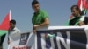 Activists hold banners in front of UN headquarters as they deliver a letter addressed to Secretary-General Ban Ki-moon in the West Bank city of Ramallah on September 8.