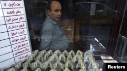 A currency exchange dealer sits at his shop as he waits for customers in Tehran's business district.