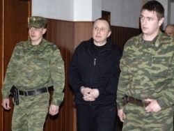 Former Yukos security chief Aleksei Pichugin is escorted at Moscow City Court in April 2008. He is serving life in prison after being convicted for involvement in the 1988 murder of Nefteyugansk Mayor Vladimir Petukhov. His supporters have called the trial a farce.