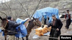 Members of an smuggling group at the Iraqi border get ready to sneak alcohol into Iran. (file photo)