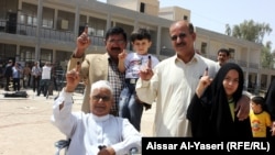 Iraqis show the indelible ink on their fingers, meant to combat voter fraud, after they voted in Najaf in the country's provincial elections on April 20.