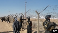 Iraqi SWAT forces stand guard outside Camp Ashraf during a protest on December 9 by Iraqis calling for the camp to be closed and for its residents to be deported.