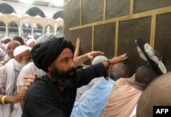 Muslim pilgrims touch the Kaaba, Islam's holiest shrine, at the Grand Mosque in Mecca on September 6.