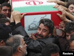 Mourners help carry the coffin of one member of the Revolutionary Guards during a state funeral.