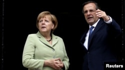 Greek Prime Minister Antonis Samaras talks with German Chancellor Angela Merkel in Athens.