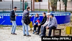 Жалақысын ала алмаған жұмысшылармен сөйлесіп тұрған Азаттық тілшілері.