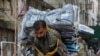 A laborer delivers packs of fabrics to a market during the lockdown in Karachi in May 2020.