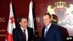 Georgian Prime Minister Nika Gilauri (left) welcomes Polish Prime Minister Donald Tusk to Tbilisi.