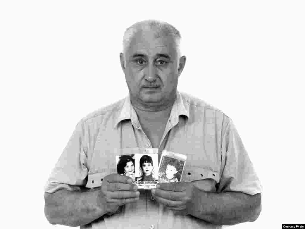 Boris Ilyin, holding photographs of his granddaughter Zarina, his daughter Elvira, and his grandson Amirkhan - Boris Ilyin brought his family from Tashkent to Ossetia to visit their historic homeland two weeks before the siege. The family decided that they should let their first-grader, Zarina, go to school in Beslan during their stay so she wouldn't miss too much of the school year. On September 1, 2004, Boris's daughter Elvira took Zarina, her 4-year-old son Amirkhan, and their 8-year-old cousin Georgy to school. Georgy was the only one who survived.