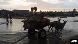 Fishermen on a donkey cart move to a safer place with their belongings at a fishing village on the outskirts in Karachi, Pakistan, on June 14 ahead of the cyclone's landfall.