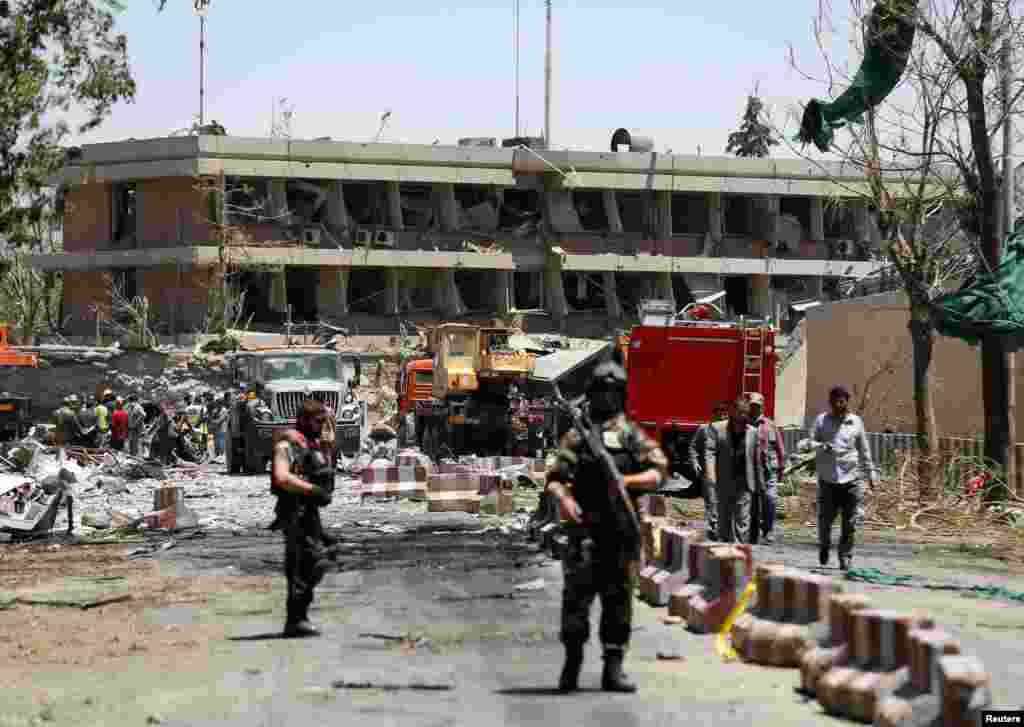 Afghan officials inspect outside the damaged German Embassy.