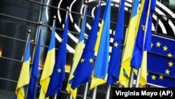 The flags of Ukraine and the European Union hang together outside the European Parliament in Brussels.