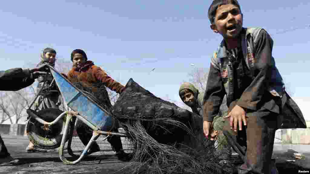 Afghan boys remove a burned tire from a Kabul street after a demonstration on February 22.