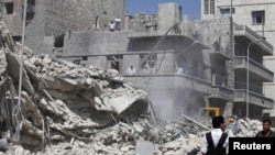 Civilians and members of the Free Syrian Army inspect a damaged building in the al-Kalaseh neighborhood of Aleppo, after a government jet air strike on September 19.