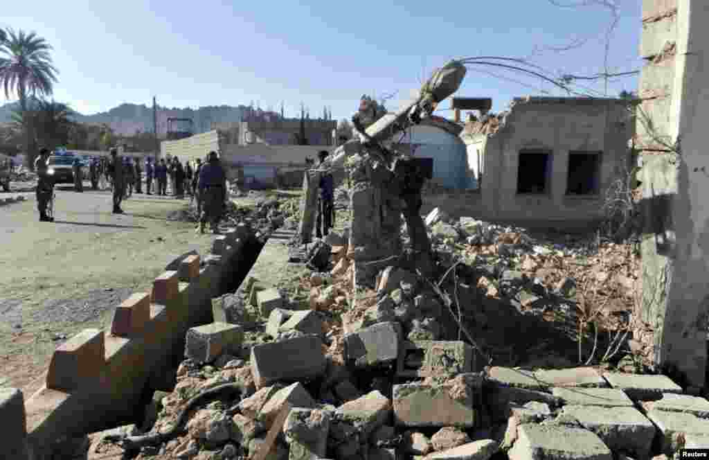 Afghan policemen stand at the site of the Taliban attack in Farah Province.