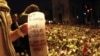 A woman holds a candle amid a sea of flowers and lit candles placed in memory of those killed in the July 22 bomb and shooting attack in front of Oslo Cathedral on July 25.