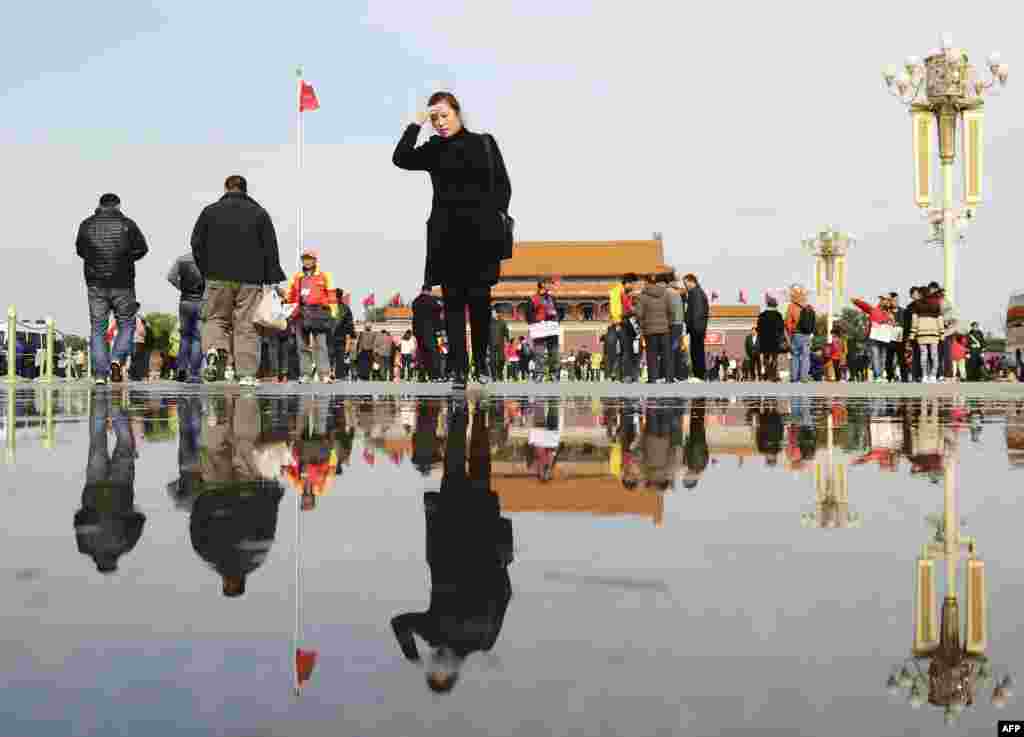 People stroll through Tiananmen Square in Beijing.