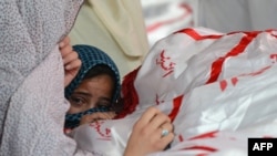 A child reacts as Shi'ite Hazaras gather around the coffin of a bomb victim on the third day of protests following the bombing in Quetta on February 19.