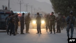 Afghan security personnel gather as they keep watch near the site of a suicide bomb attack near the Marshal Fahim military academy base in Kabul on October 21.