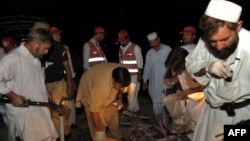 Pakistani security officials collect evidence from the site of a suicide bomb attack in Peshawar on June 11.