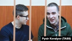 Viktor Filinkov (left) and Yuly Boyarshinov sit inside a defendants' cage during a hearing at a military court in St. Petersburg on February 25. 