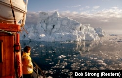 A tourist taking in the icy seascape of Disko Bay, Greenland, in May 2007