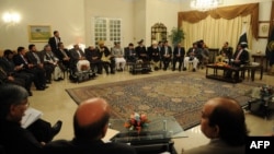 Pakistani Prime Minister Raja Pervez Ashraf (top right) talks with Afghan parliament members during a meeting in Islamabad on December 11.