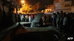 Karachi residents gather around the site of a bomb explosion in that port city in early August.