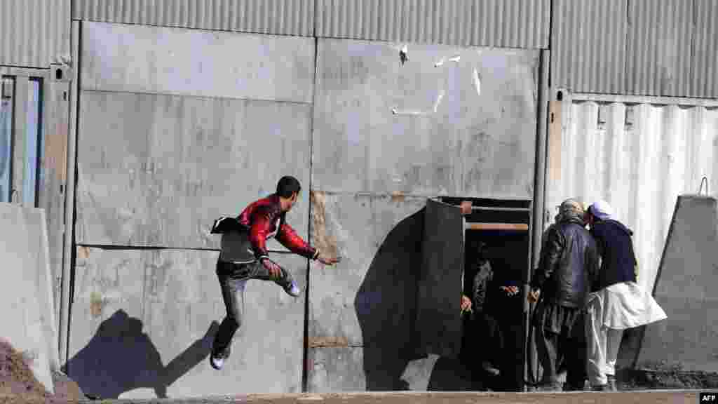 An Afghan protester kicks a gate to a foreign army base gate during a Kabul protest on February 22.