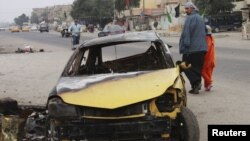 An Iraqi man and his daughter walk past the site of a bomb attack in northern Baghdad on December 23.