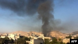 Smoke rises from the site of explosions in central Damascus on September 26.