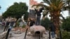 People stand atop a toppled statue of Syria's late president Hafez al-Assad in Damascus on December 8.