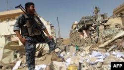 A policeman inspects damages following a June 4 bomb attack on the Shi'ite endowment headquarters in central Baghdad.