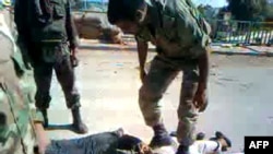 An undated screen grab from YouTube appears to show Syrian security forces beating handcuffed and blindfolded detained men near the central city of Homs