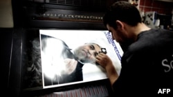 A man checks a printed electoral poster of presidential candidate and former top nuclear negotiator Hassan Rohani at a printing house in Tehran on May 26.