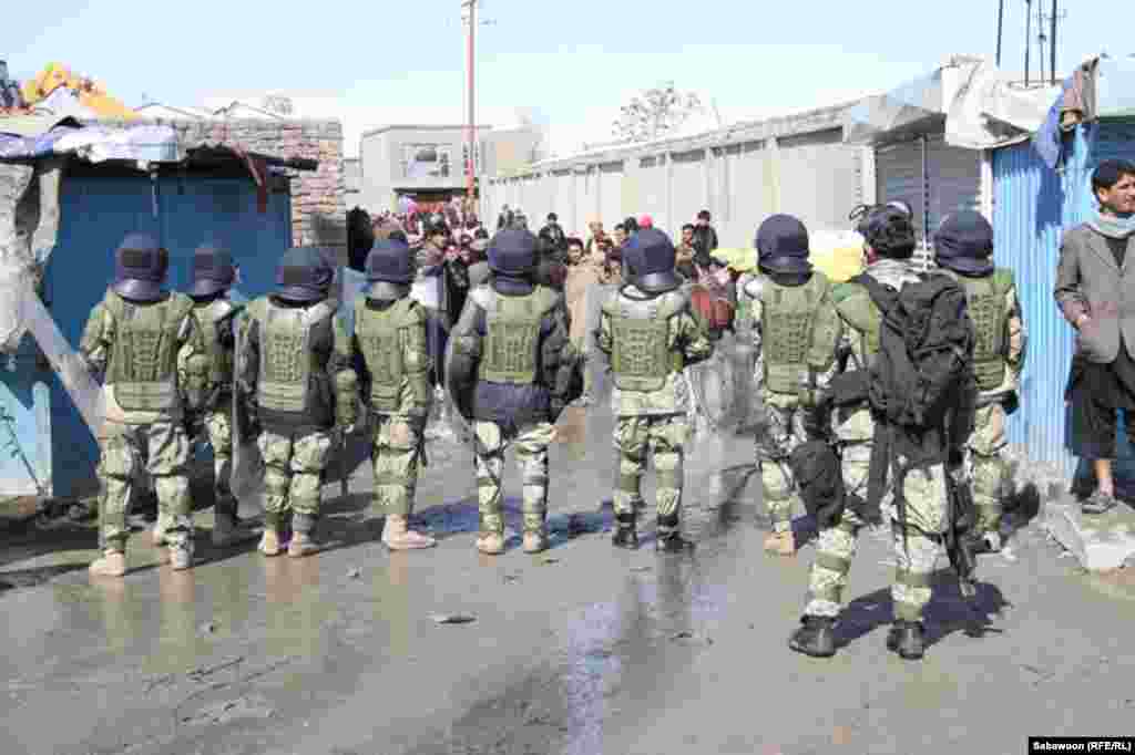 Afghan security forces square off in front of a scattered crowd in Kabul during February 22 protesting.