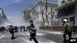 A demonstrator flees from Greek riot police during a protest in Athens on May 11. Thousands of Greeks took to the streets amid a new raft of government austerity measures designed to forestall a costly debt overhaul.