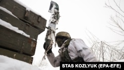 A Ukrainian serviceman checks the situation at a front-line position near the city of Donetsk. 