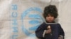 An Afghan girl waits while her mother receives food aid from the UNHCR in Kabul earlier this month.