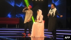 Afghan singer Zulala Hashemi (center) performs alongside competitors Sayed Jamal Mubarez (left) and Babak Mohammadi during the television music competition Afghan Star in Kabul in 2017.