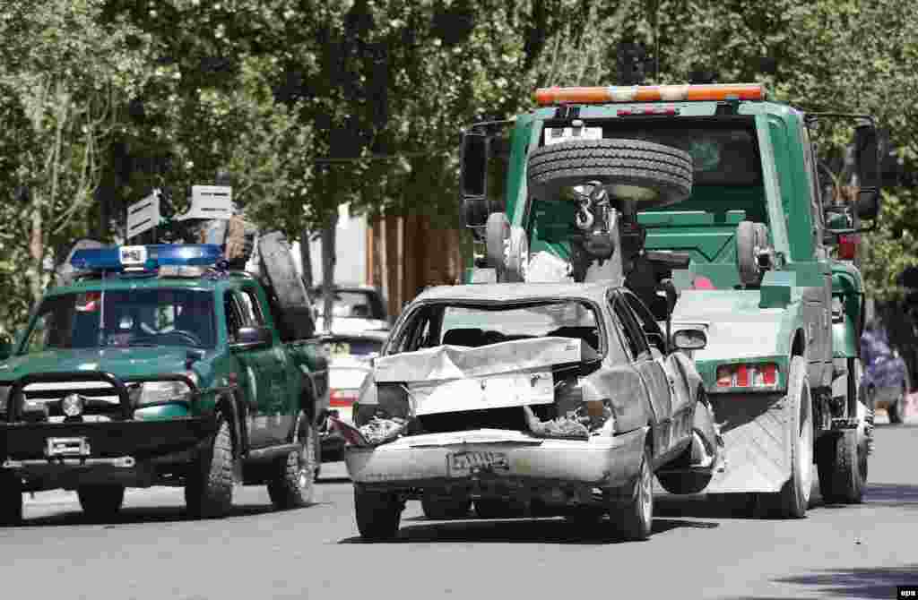 A vehicle that was damaged in the blast is removed from the scene.