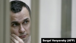 Ukrainian film director Oleg Sentsov stands inside a defendants' cage during a hearing at a military court in the city of Rostov-on-Don in July 2015.