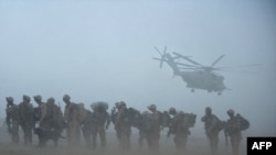 U.S. marines wait for helicopter transport in Helmand Province, a key site in the fight against Taliban militants.