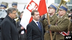 Russian President Dmitry Medvedev (center) and Polish President Bronislaw Komorowski inspect an honor guard during a welcoming ceremony in Warsaw.